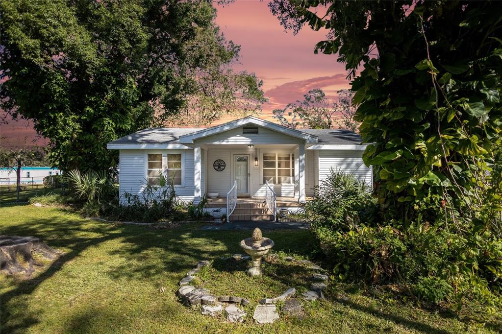 a front view of house with yard and trees around