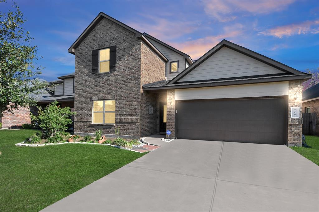 a front view of a house with a yard and garage