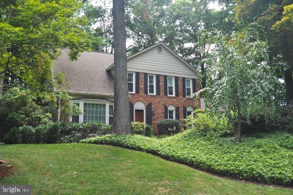 a front view of a house with a yard and trees