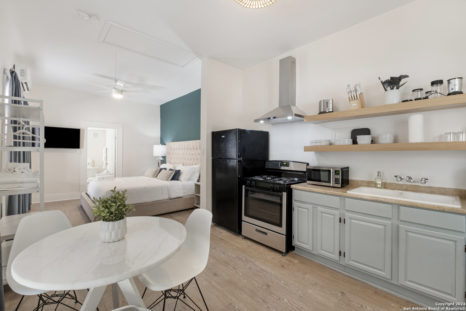 a kitchen with stainless steel appliances a white table and chairs