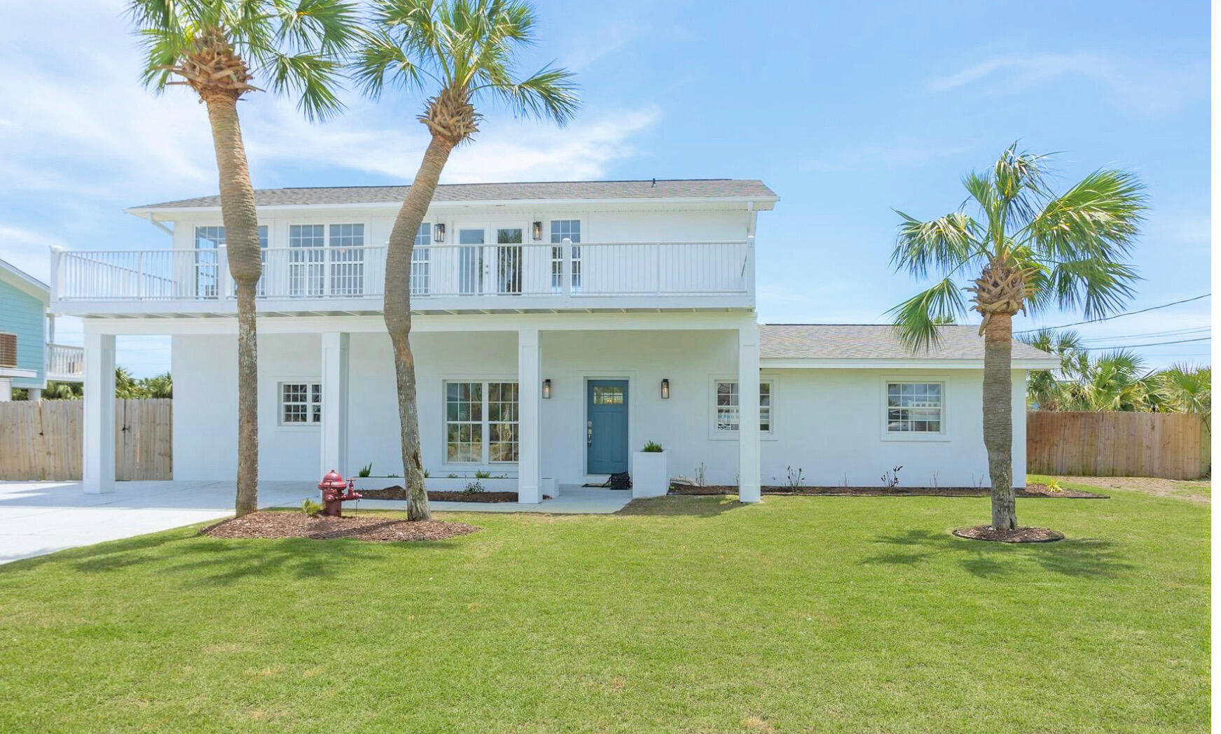 a view of a house with a yard and palm trees