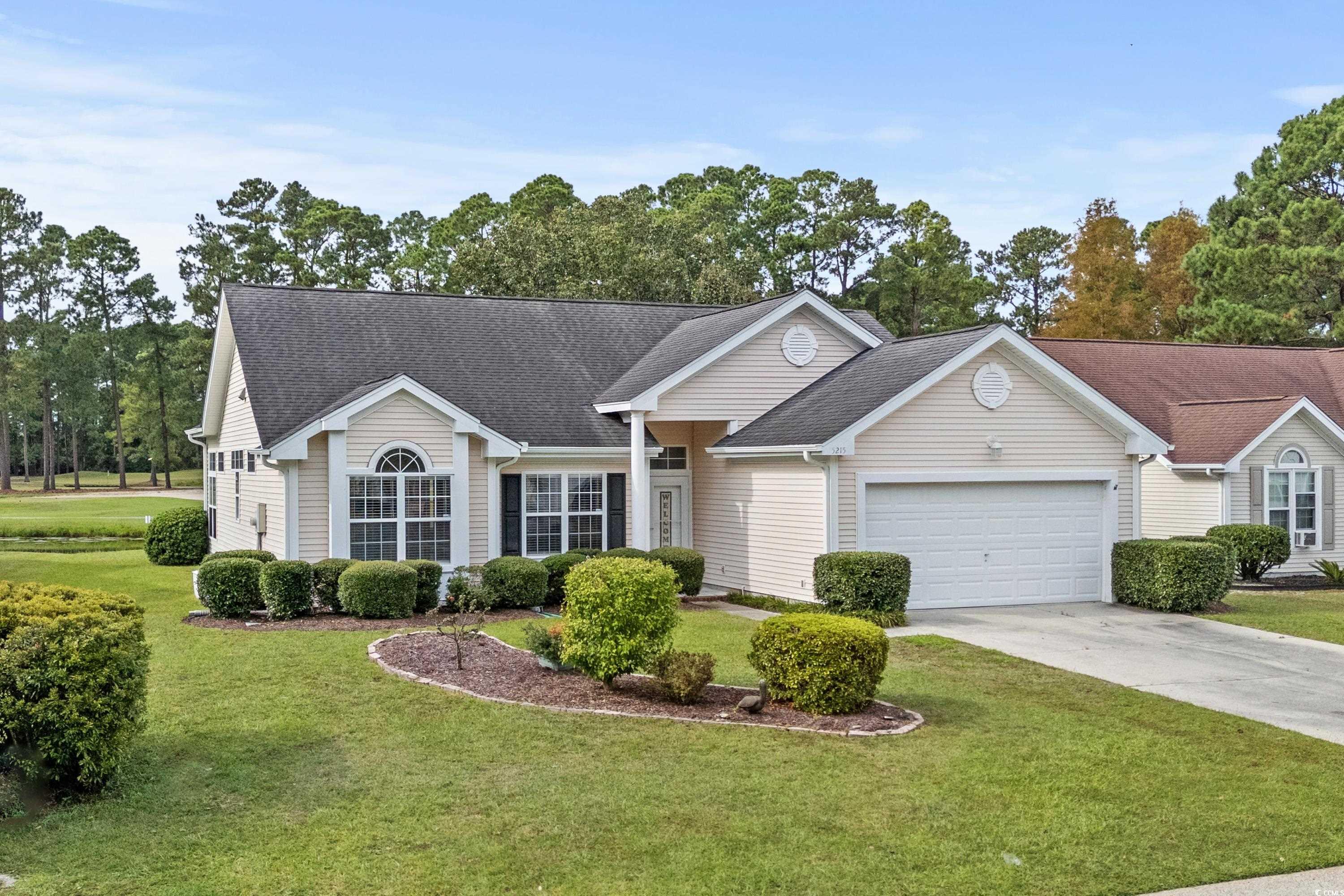 Ranch-style home featuring a front yard and a gara