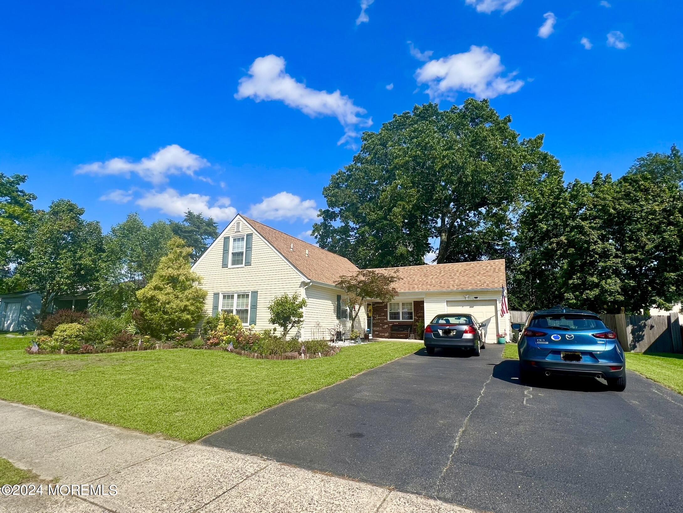 a view of a car parked in front of a house with a yard