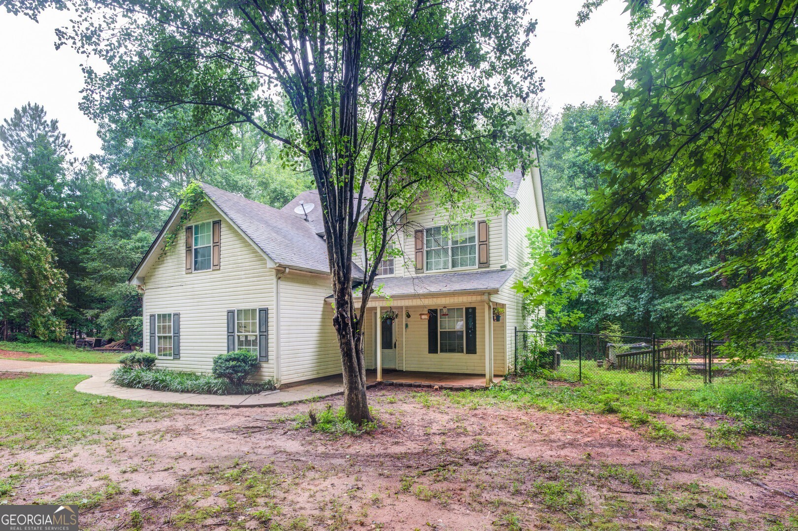 a view of a house with a yard and large tree