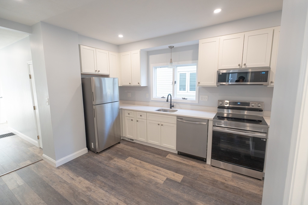 a kitchen with a refrigerator sink and cabinets