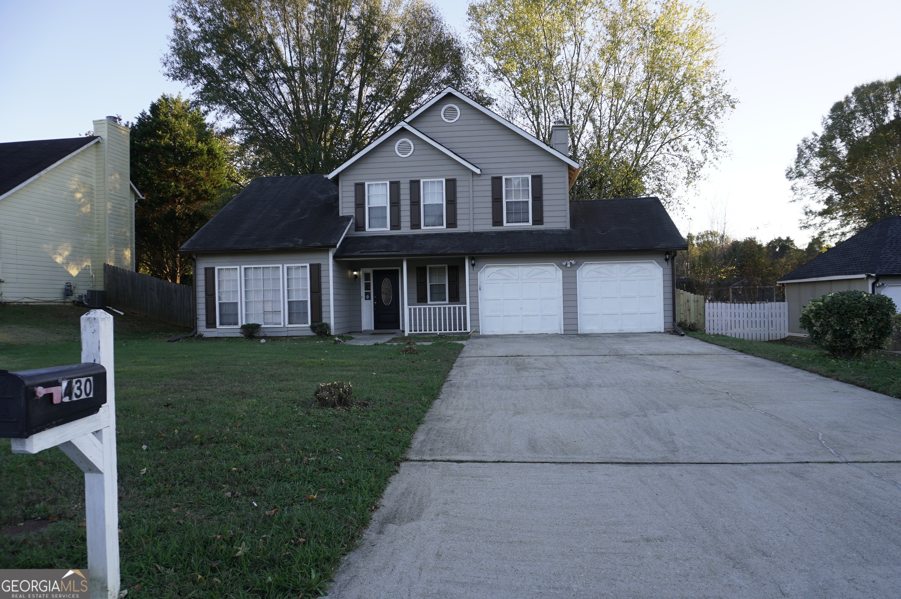 a front view of a house with a garden and plants