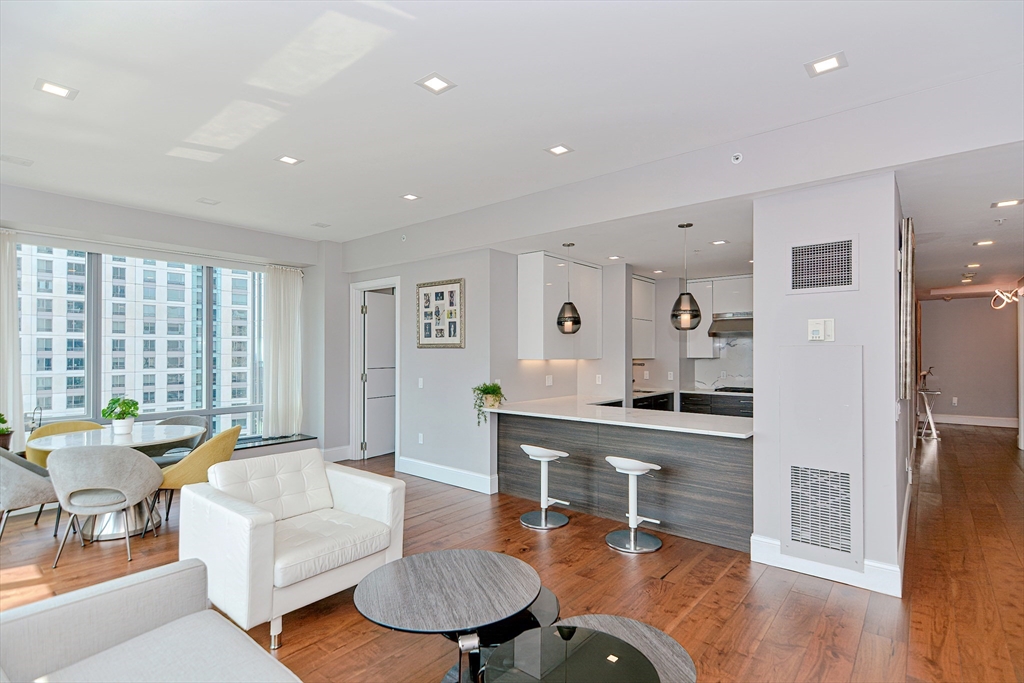 a living room with furniture a wooden floor and a large window