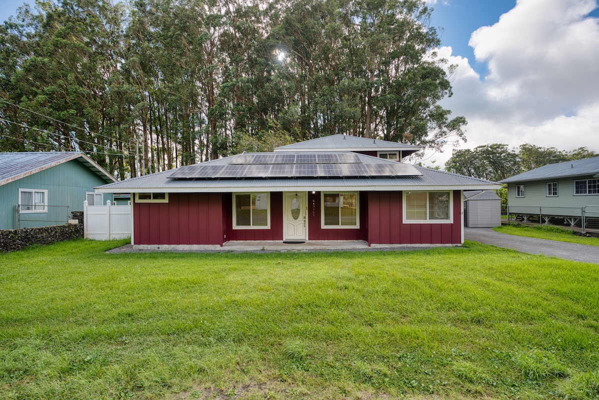 a front view of a house with yard and deck