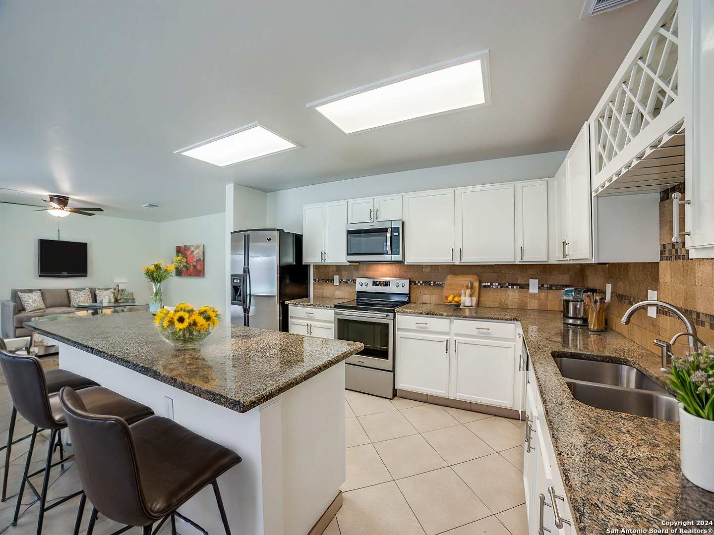 a kitchen with stainless steel appliances granite countertop a sink a stove top oven a counter space and cabinets