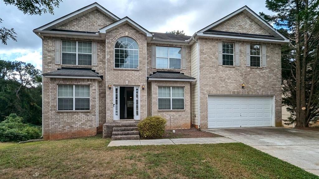 a front view of a house with a yard and garage