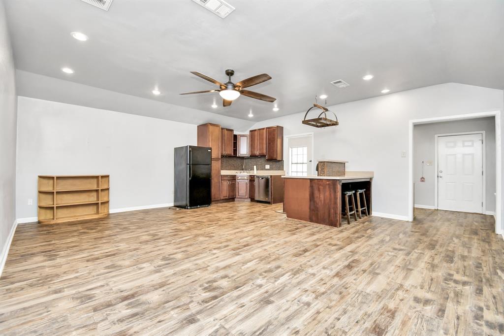 a kitchen with stainless steel appliances kitchen island granite countertop a refrigerator and a sink