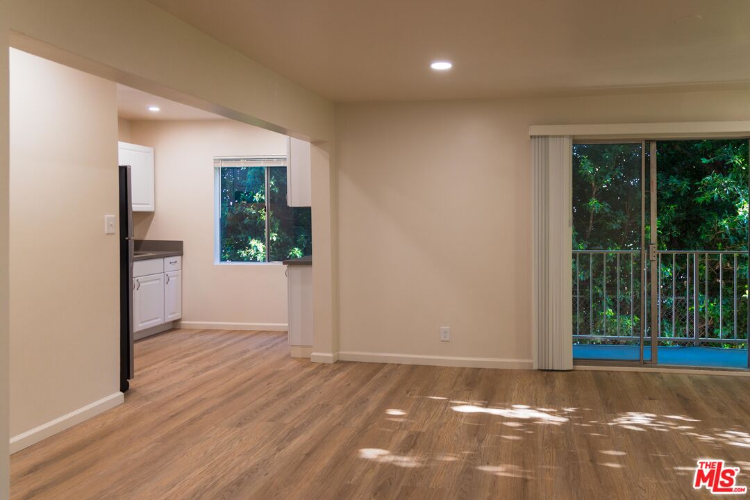 a view of a room with wooden floor and a window