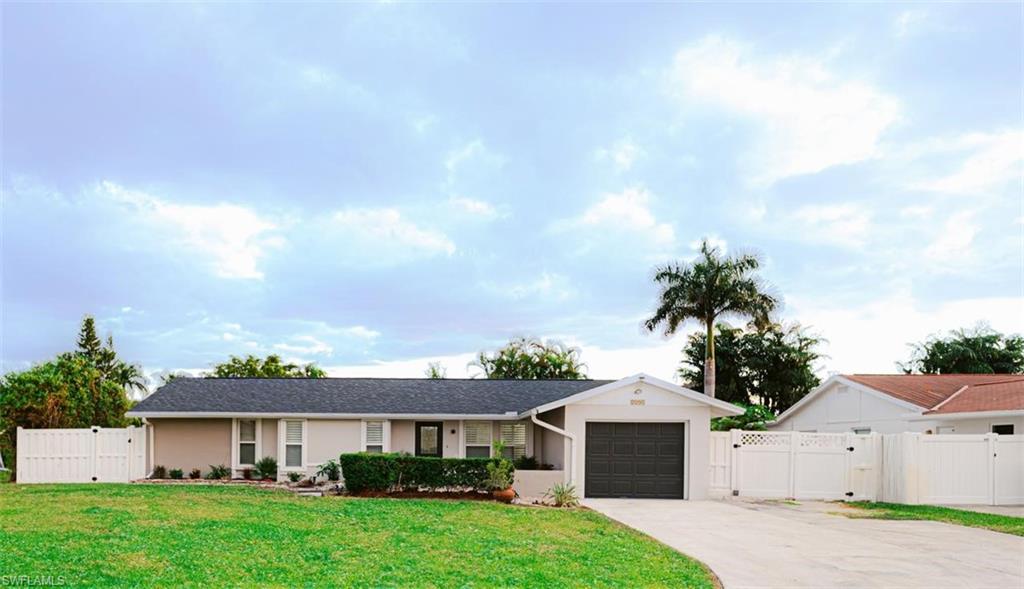 Ranch-style home featuring a front yard and a garage