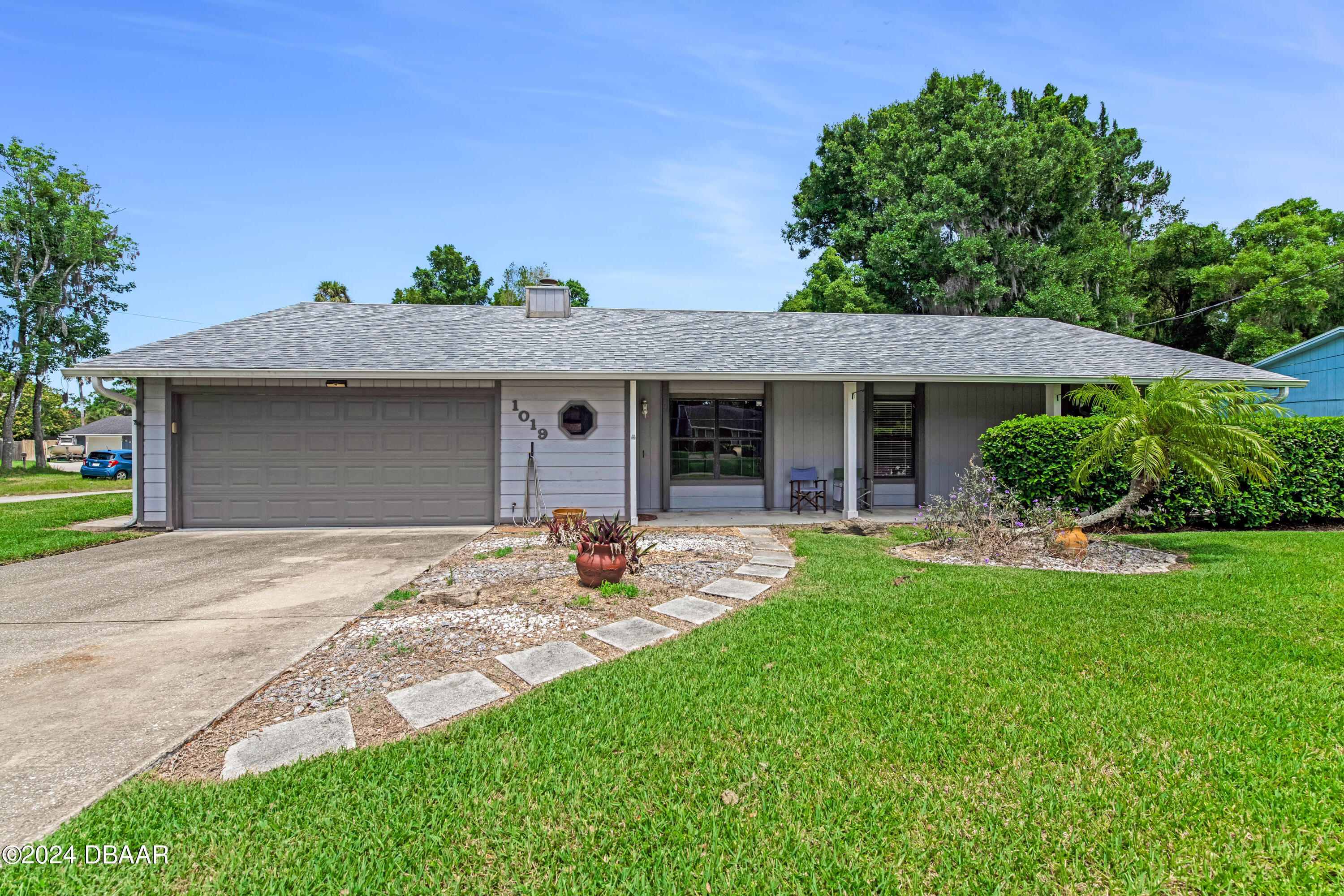 a front view of a house with a garden and yard