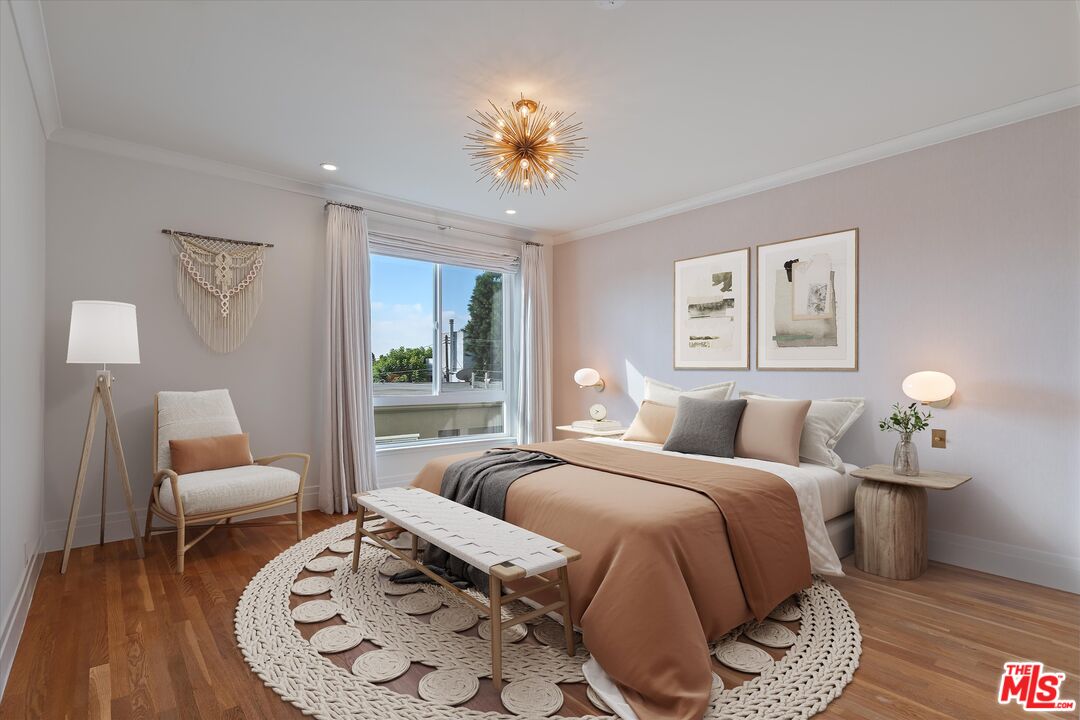 a spacious bedroom with a bed a couch and potted plant on the table