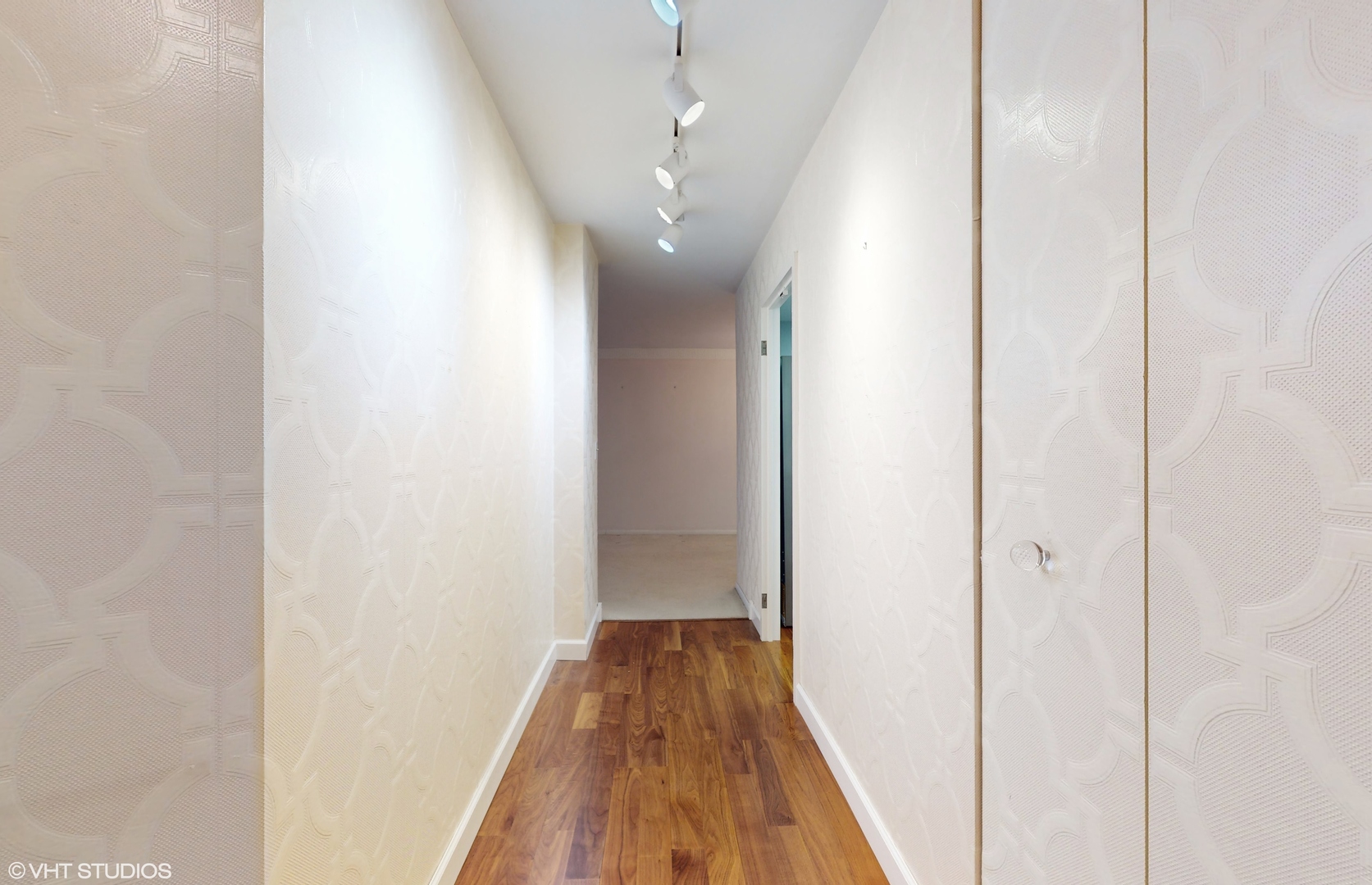 a view of a hallway with wooden floor