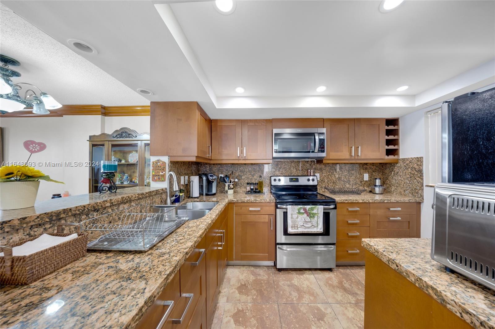 a kitchen with stainless steel appliances granite countertop a stove top oven a sink a counter space and cabinets