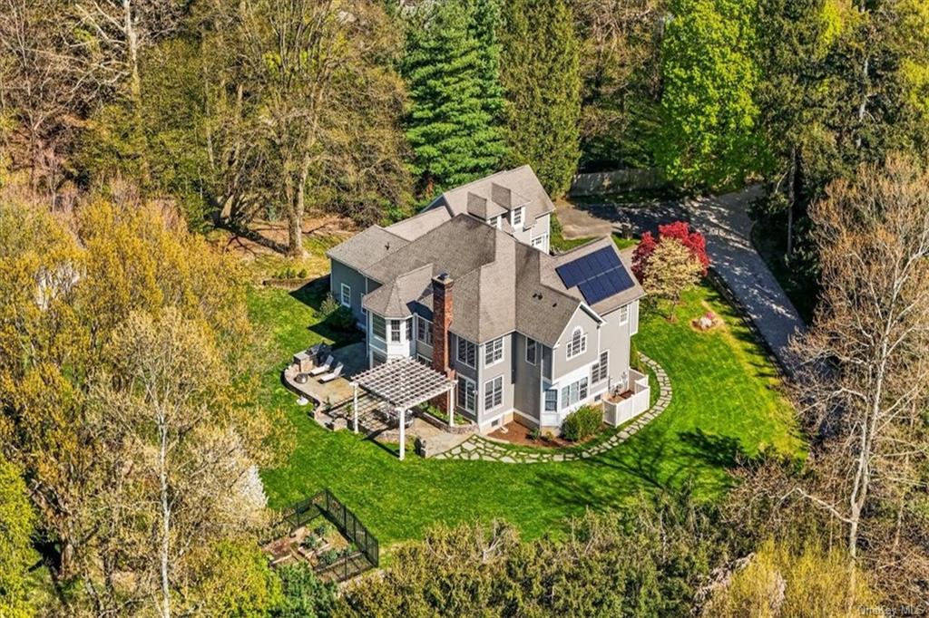 an aerial view of a house with swimming pool and garden