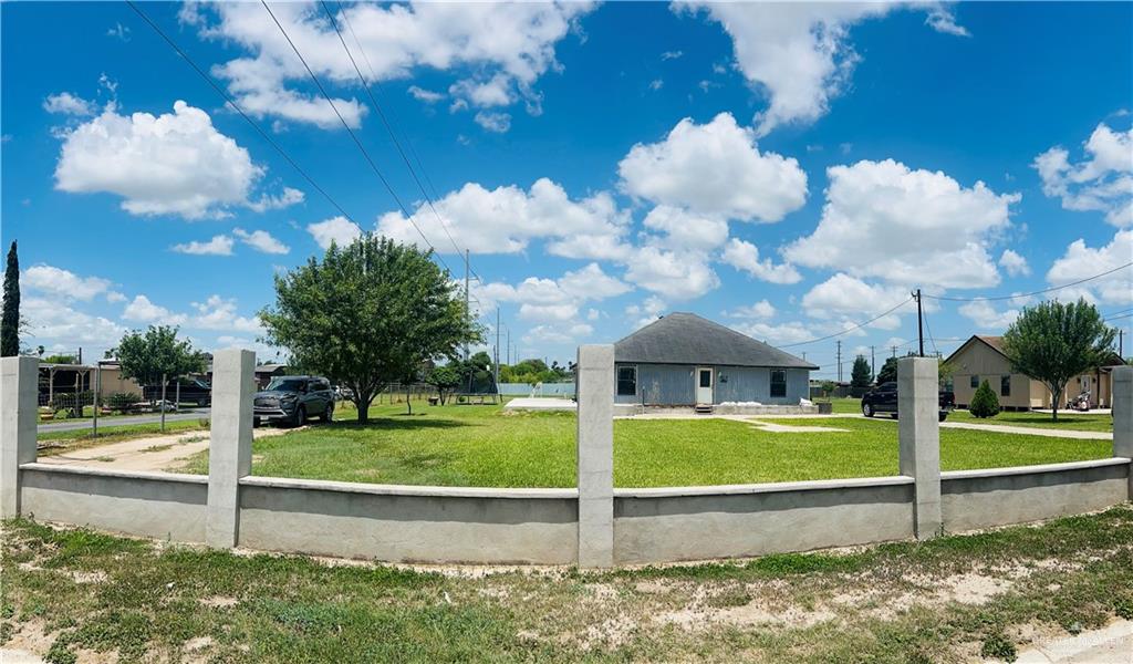 a view of a fountain in front of a house with a big yard