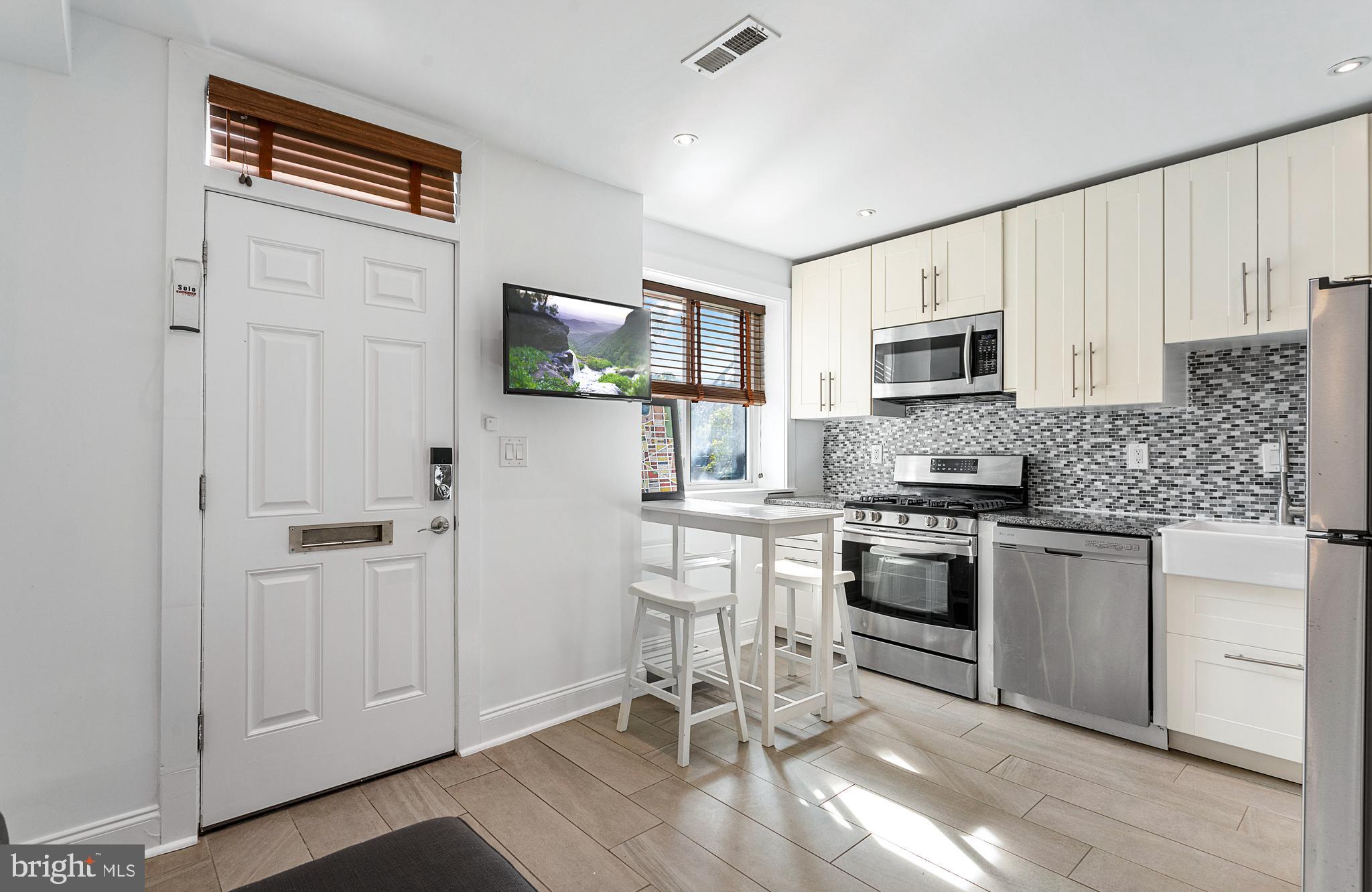 a kitchen with cabinets stainless steel appliances and a window