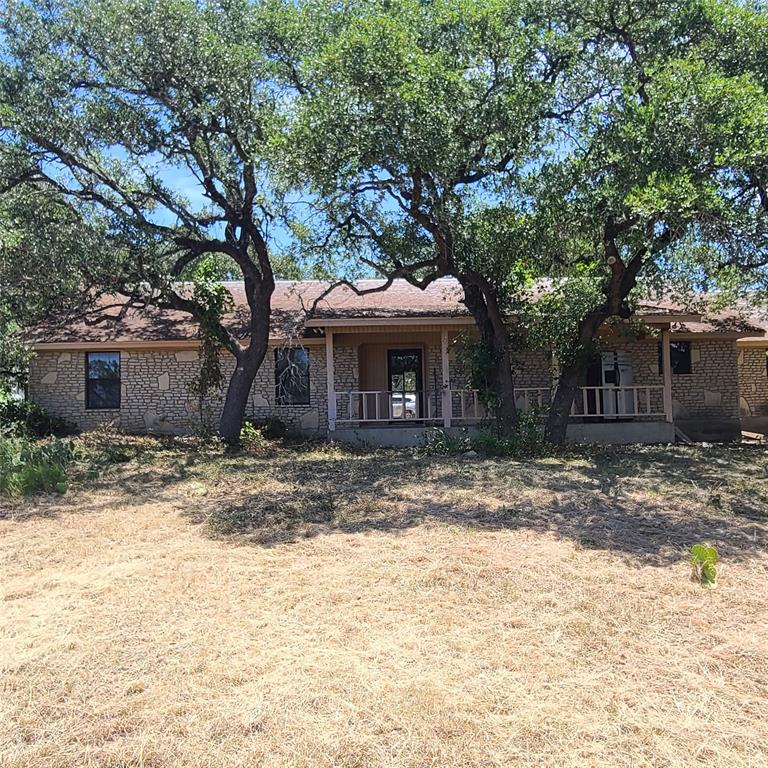 a front view of a house with a tree