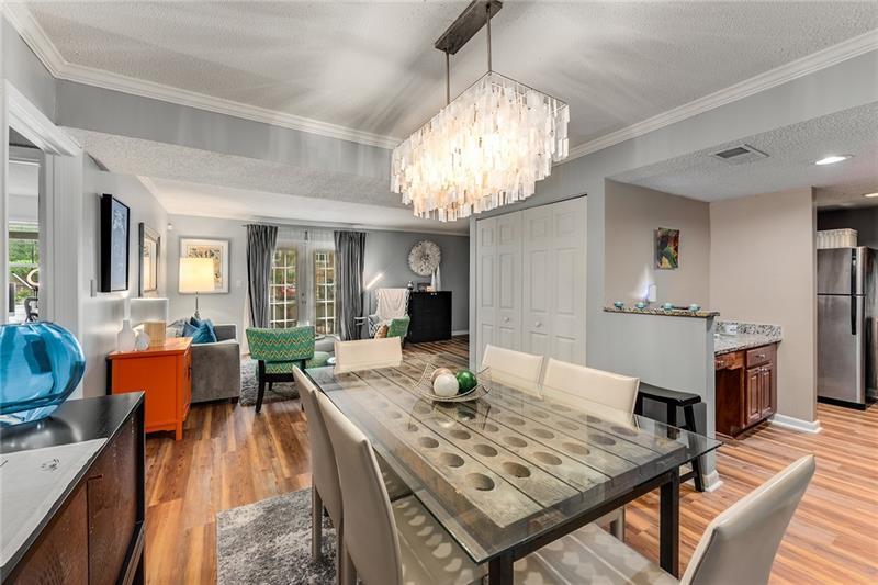 a view of a dining room with furniture a chandelier and wooden floor