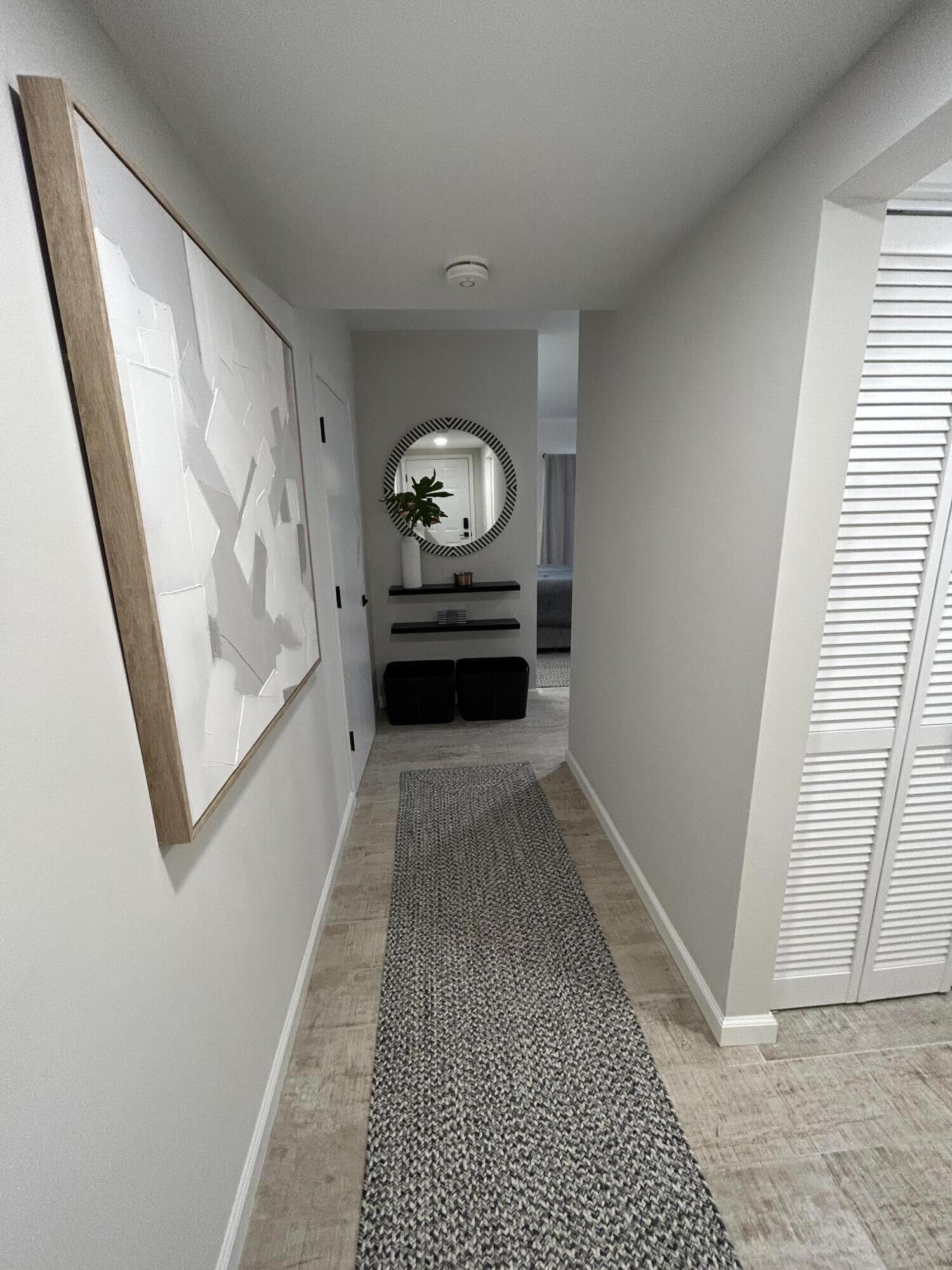 a view of a hallway to a livingroom with furniture