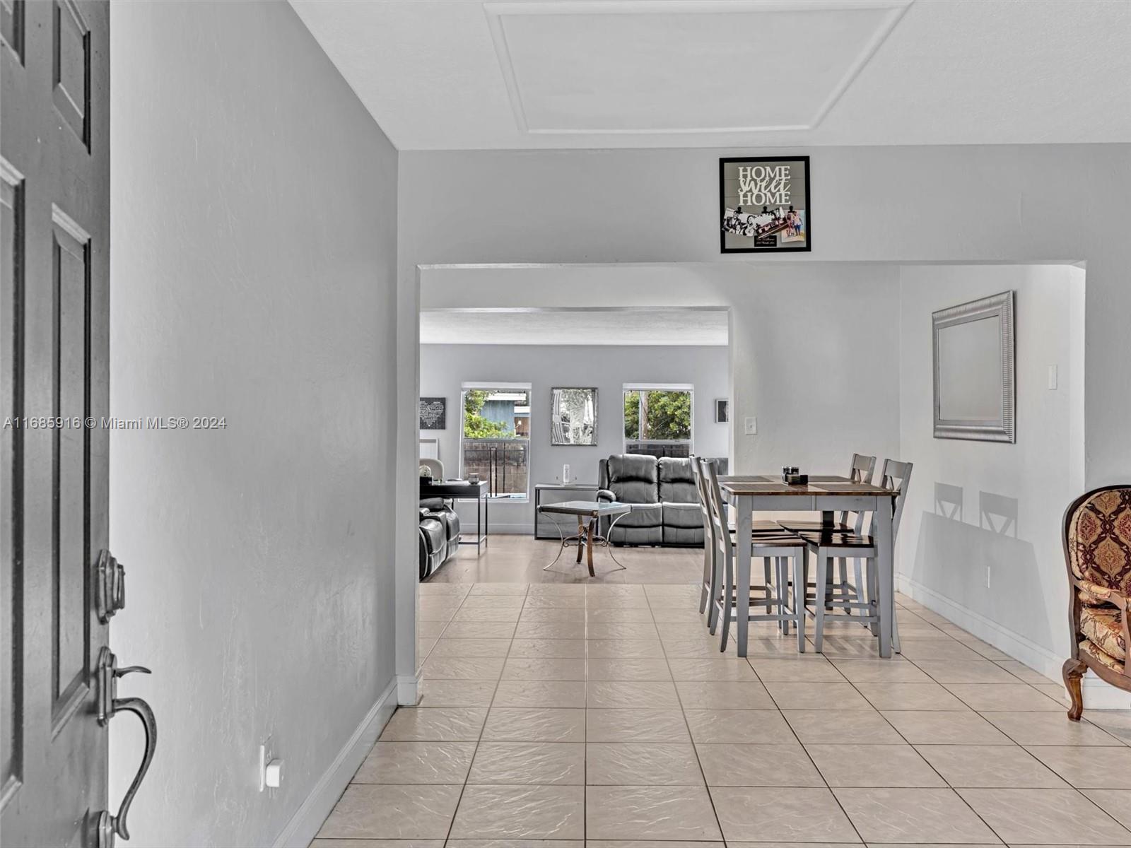 a dining room with furniture and a floor to ceiling window