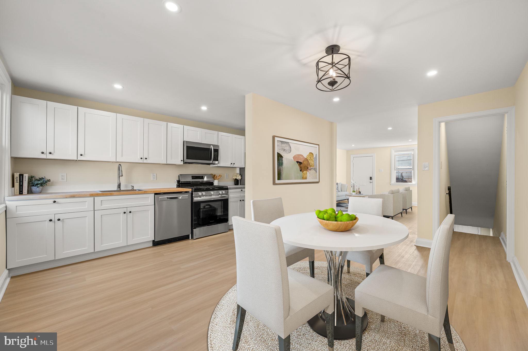 a kitchen with stainless steel appliances a dining table and chairs