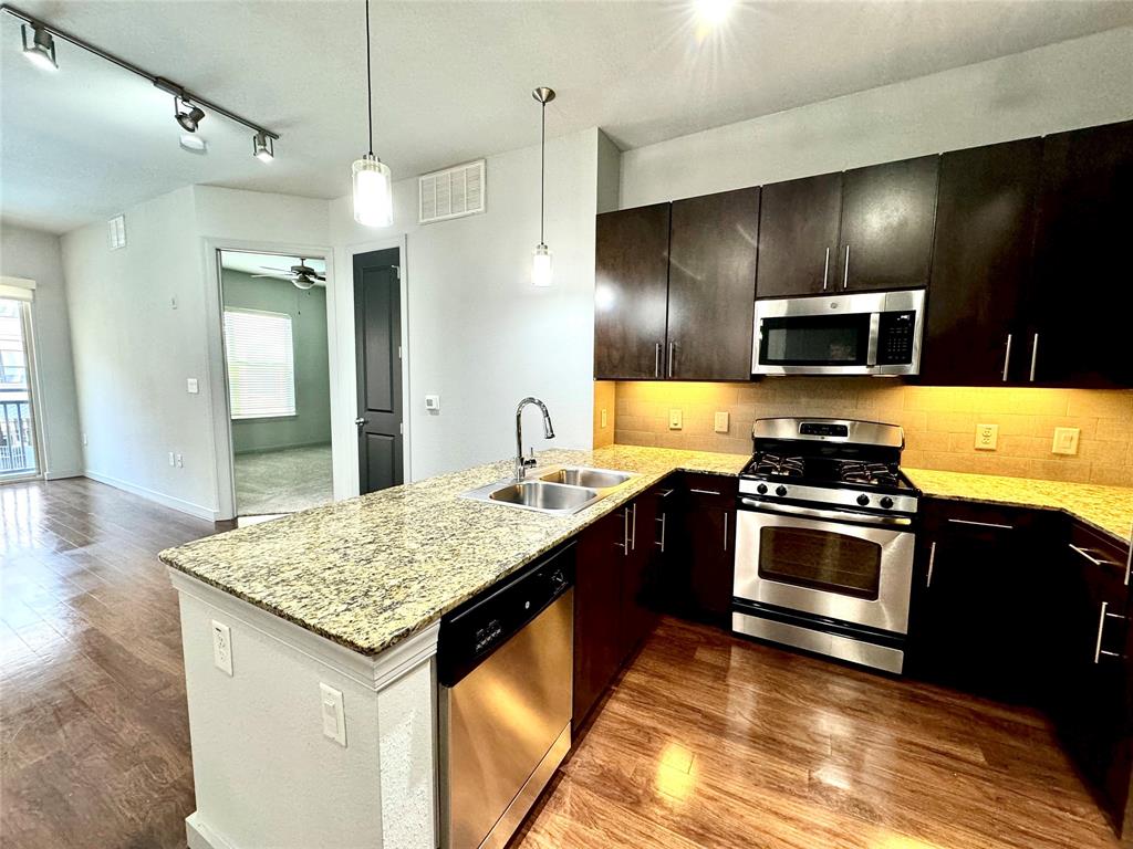 a kitchen with stainless steel appliances granite countertop a sink stove and refrigerator