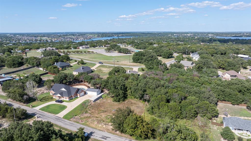 an aerial view of a residential houses with outdoor space and trees