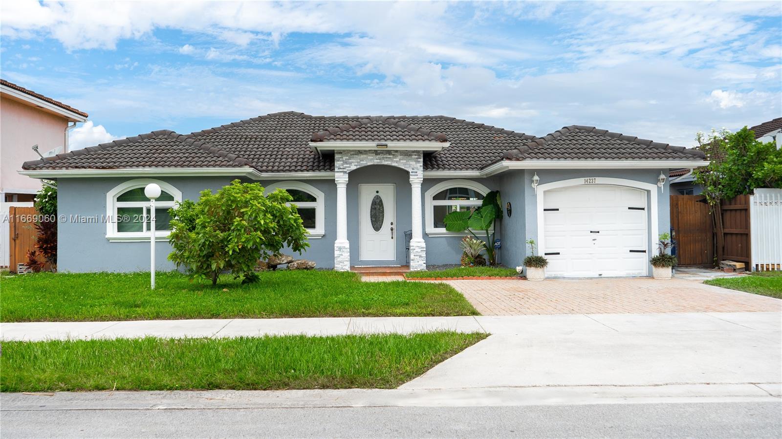 a front view of a house with a garden and yard