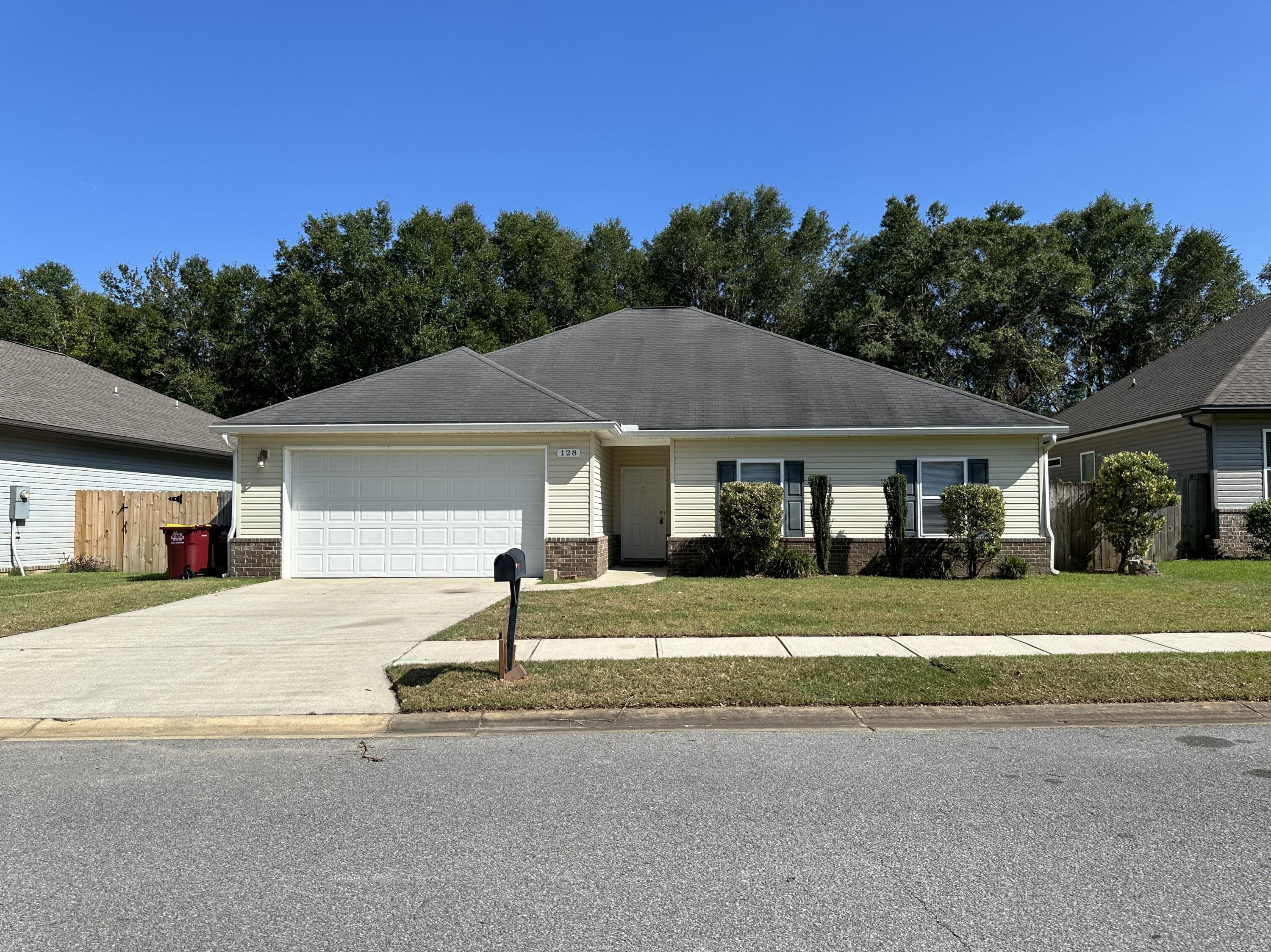 a yellow house with a yard and a large parking space