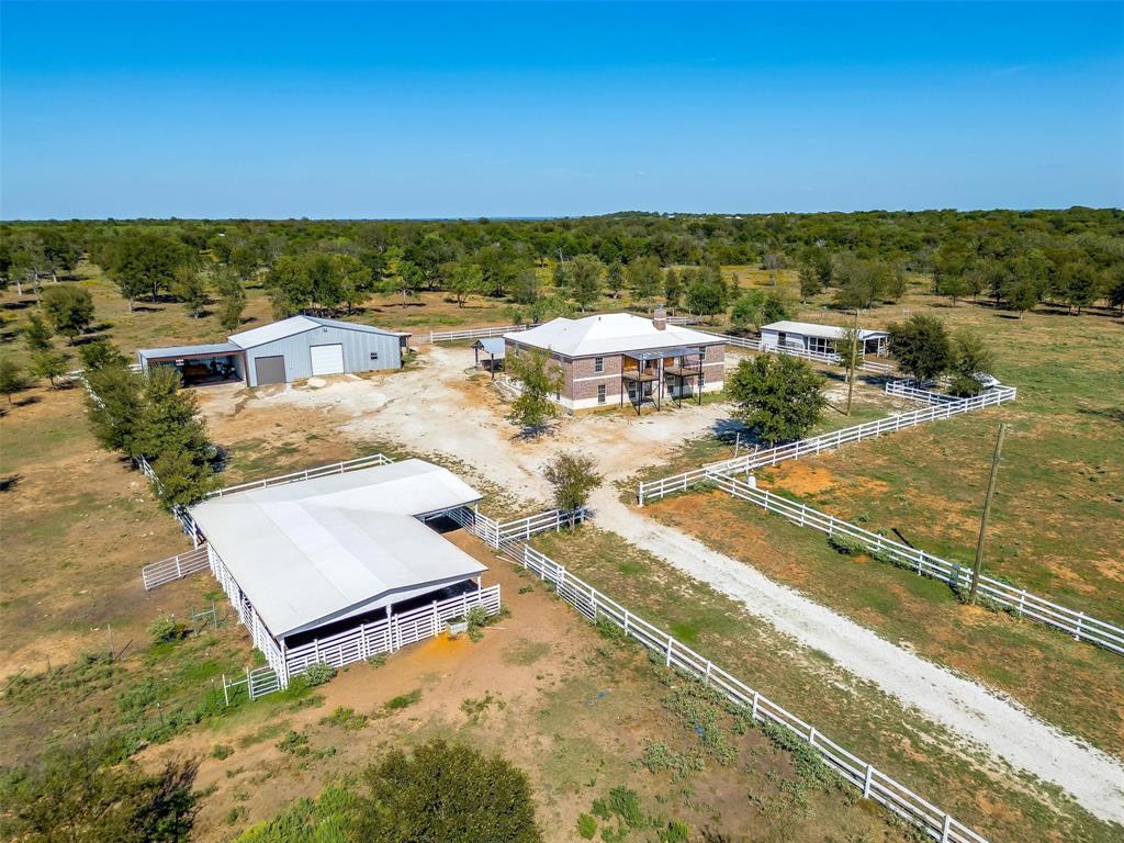 Breathtaking aerial view capturing the home, stables, spacious warehouse, and vibrant animal areas.