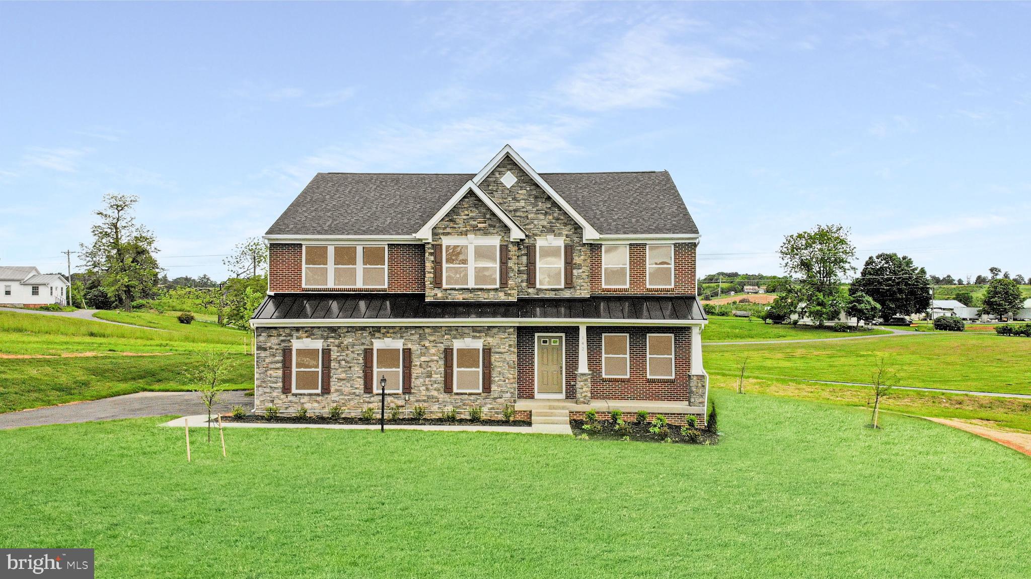 a front view of a house with a garden and yard