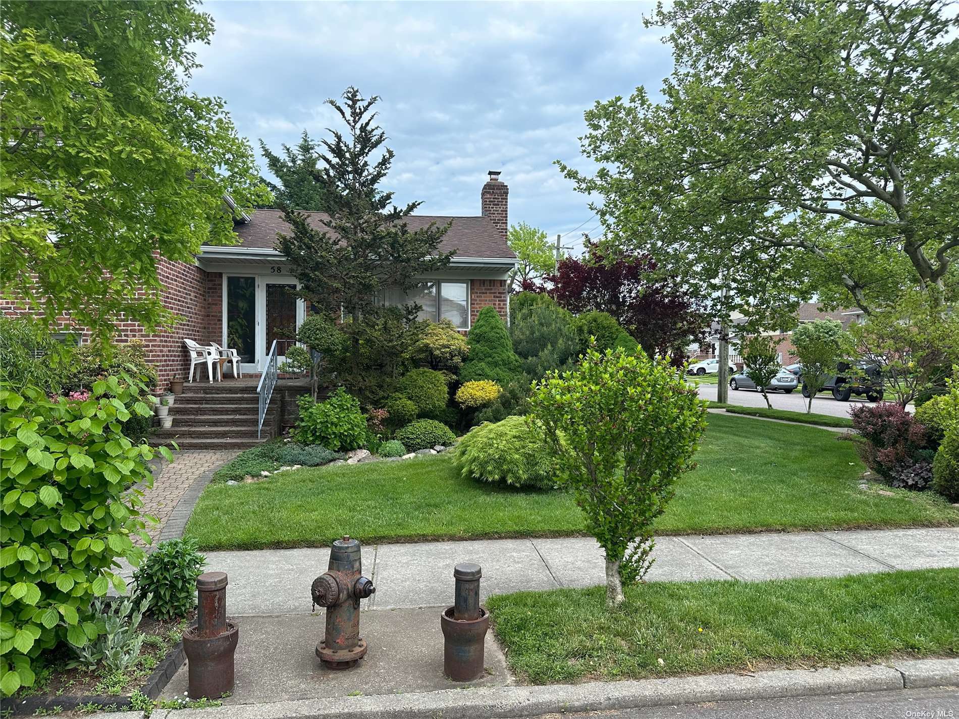 a view of house with a yard and potted plants