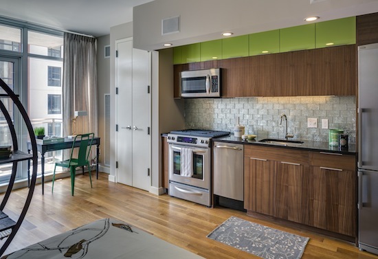 a kitchen with granite countertop a stove a sink and a microwave