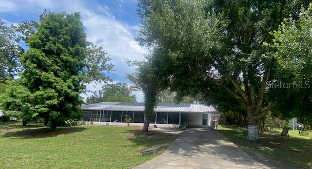 a front view of a house with a garden and trees