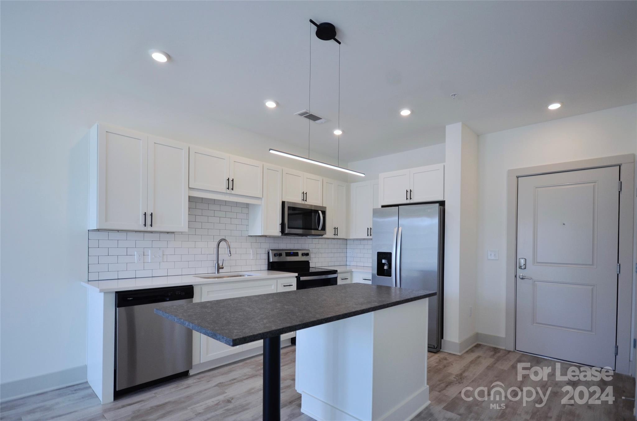 a kitchen with stainless steel appliances a refrigerator sink and microwave