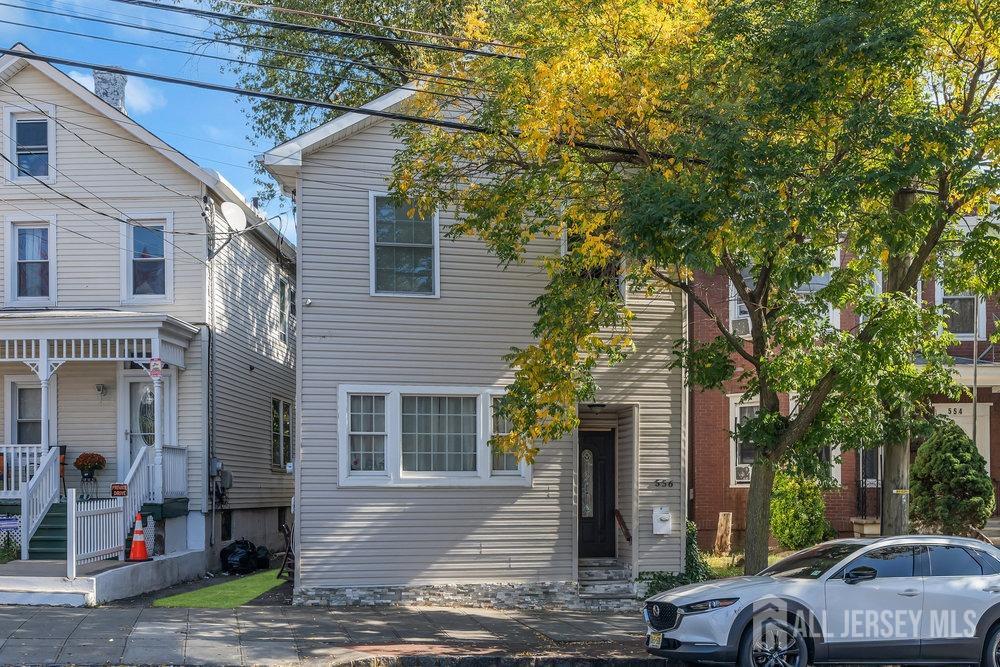 a front view of a house with a tree