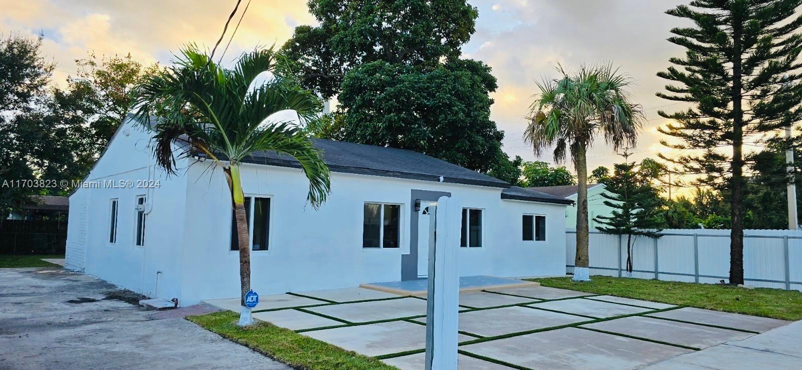 a view of backyard of house with palm trees