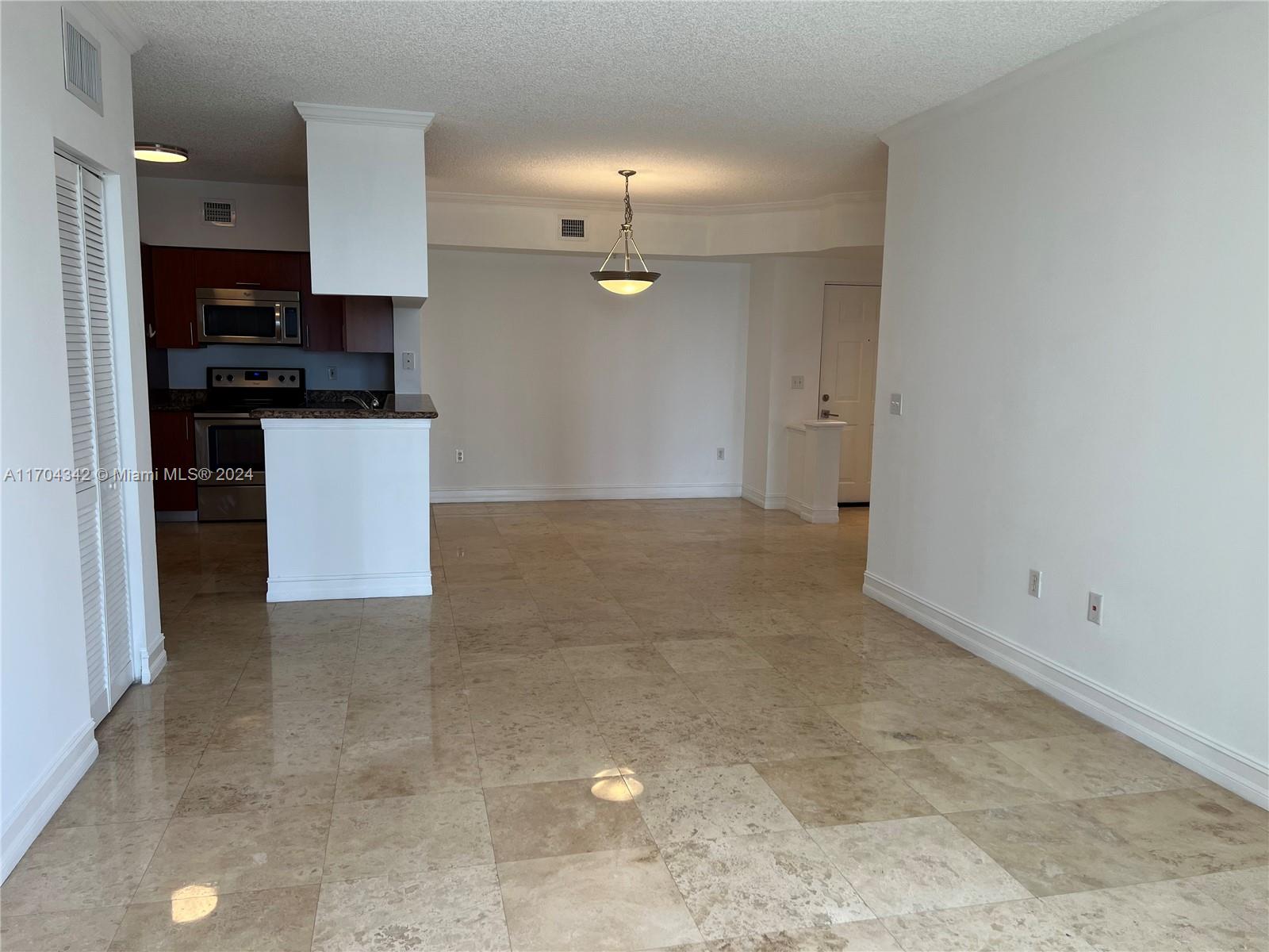 a view of kitchen with kitchen island stainless steel appliances a sink cabinets and a counter top space