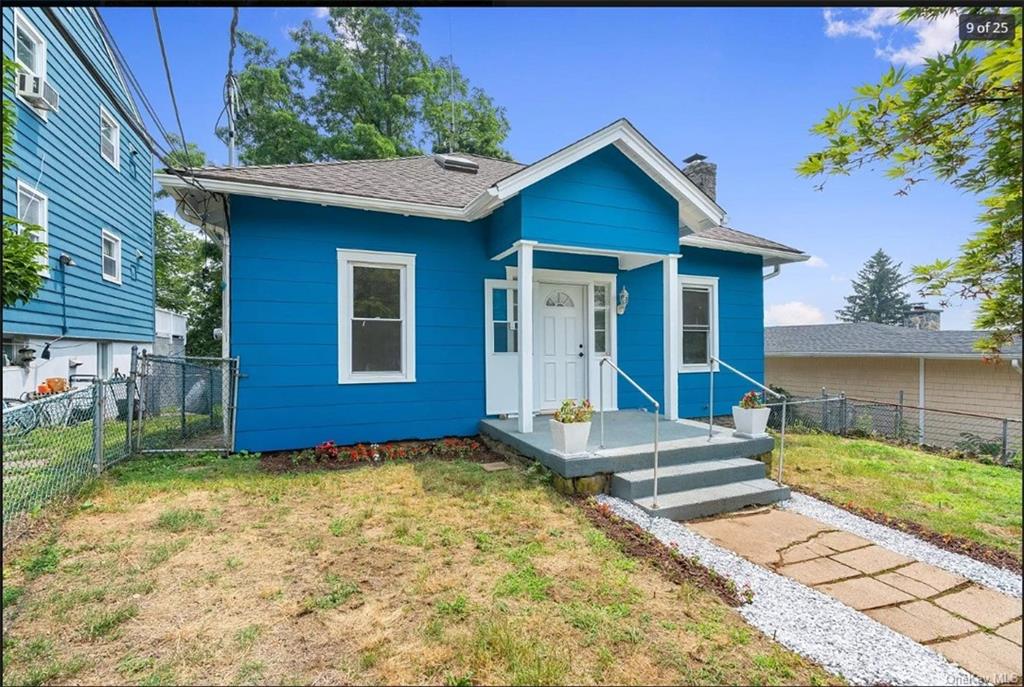 a view of a house with wooden fence next to a yard