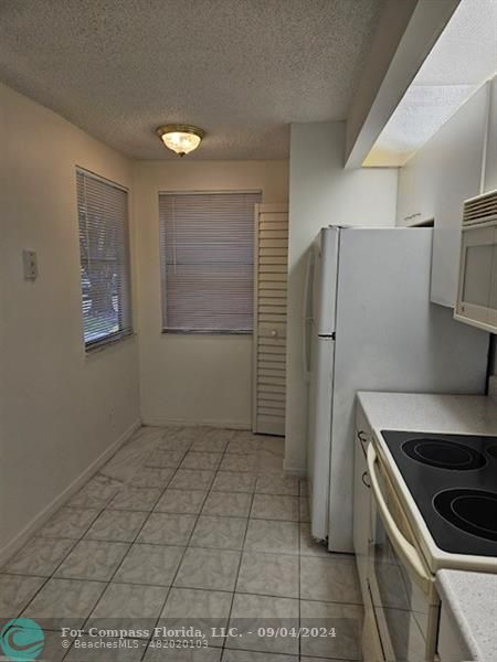 a kitchen with a refrigerator and a stove top oven