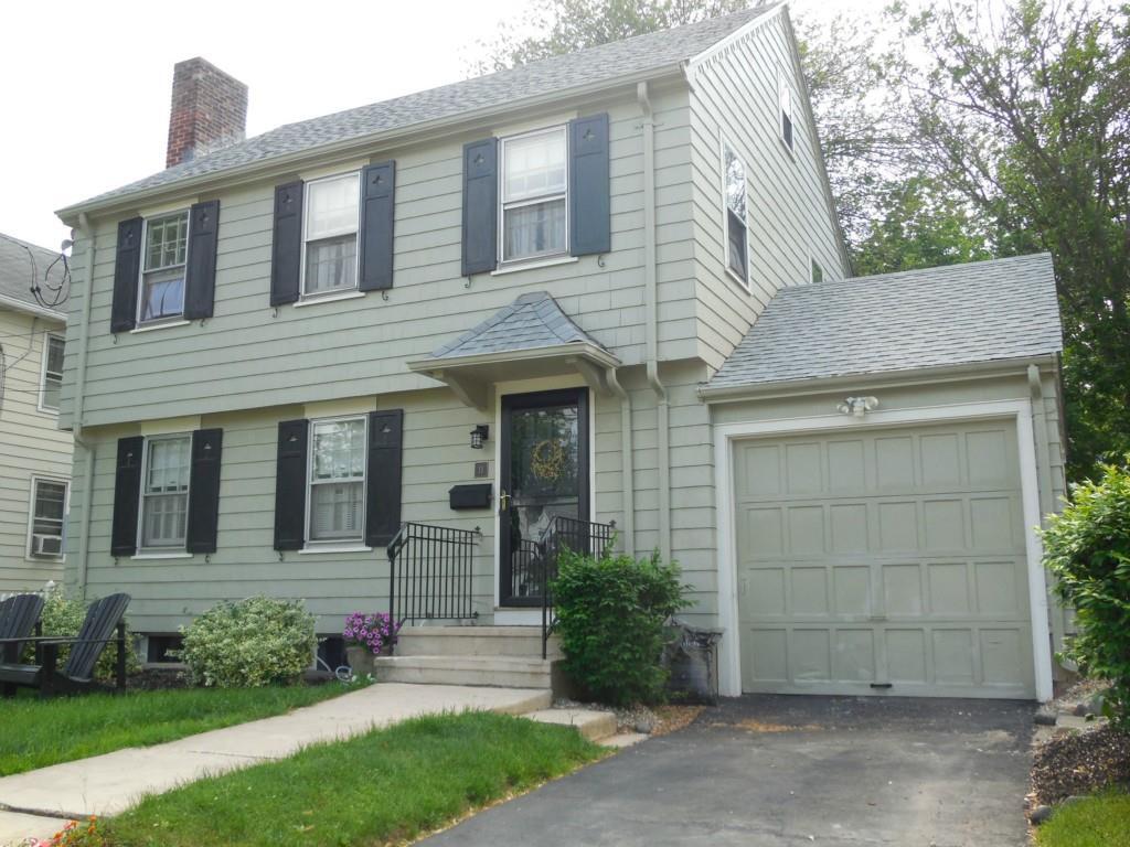 a front view of a house with a garden and yard