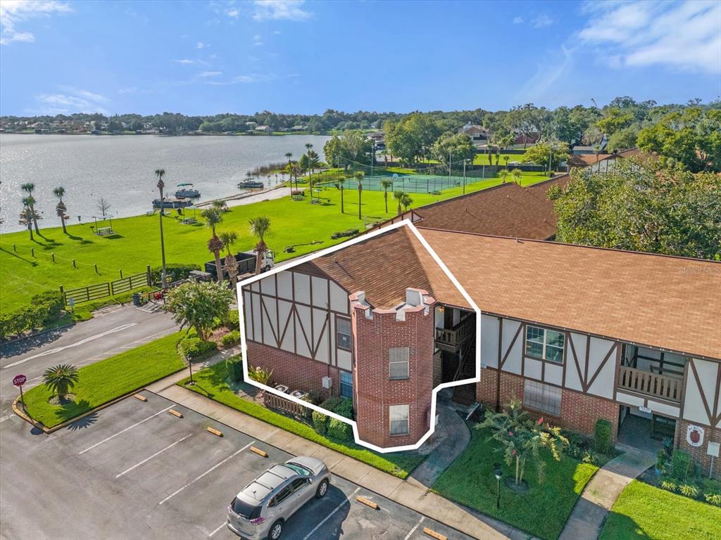 an aerial view of a house with outdoor space and lake view in back