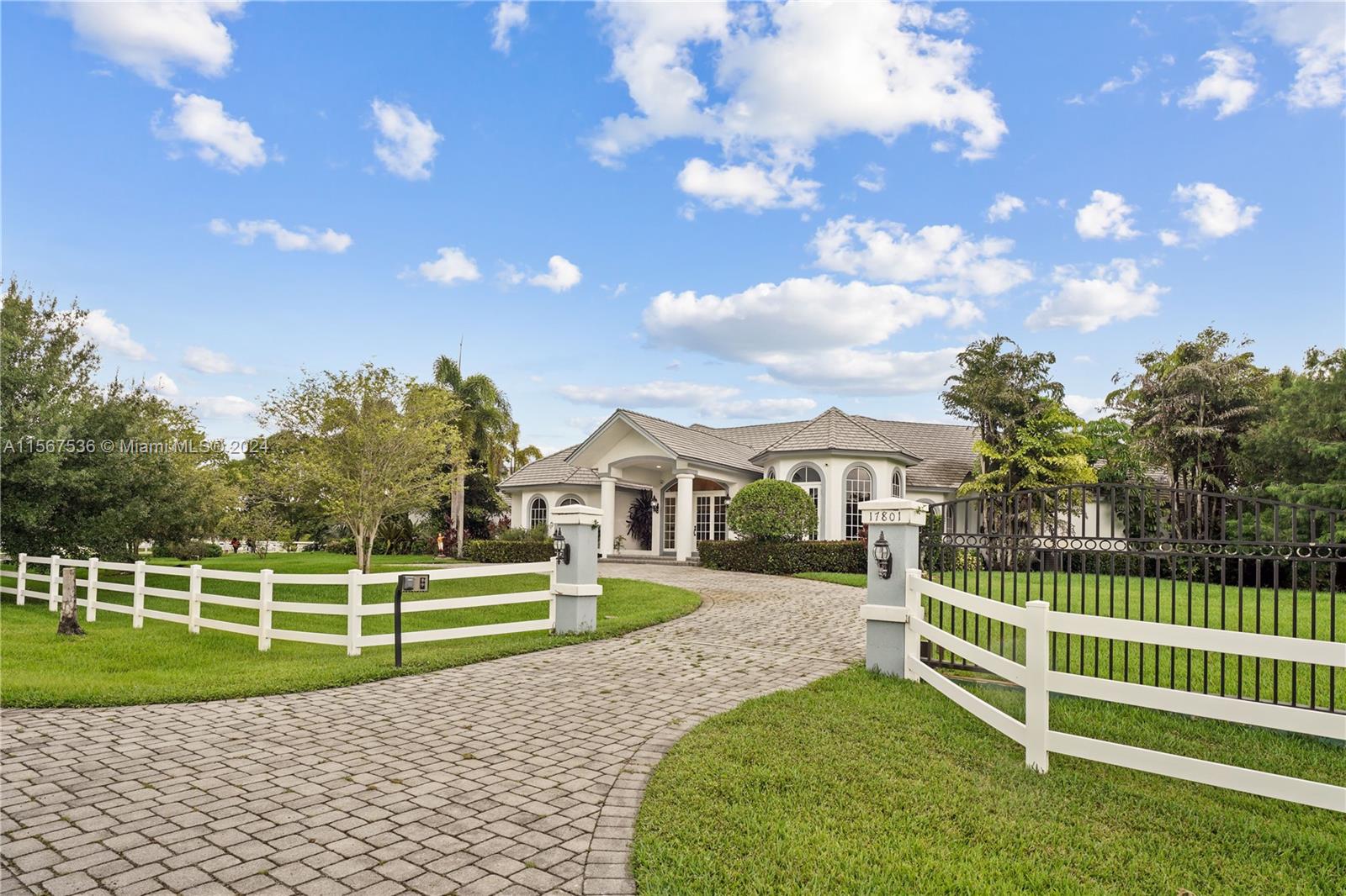 a view of a house with a big yard and a large tree