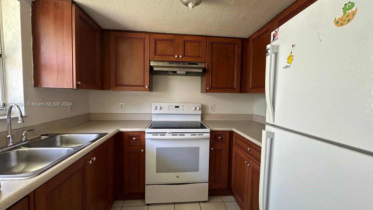 a kitchen with a stove sink and cabinets