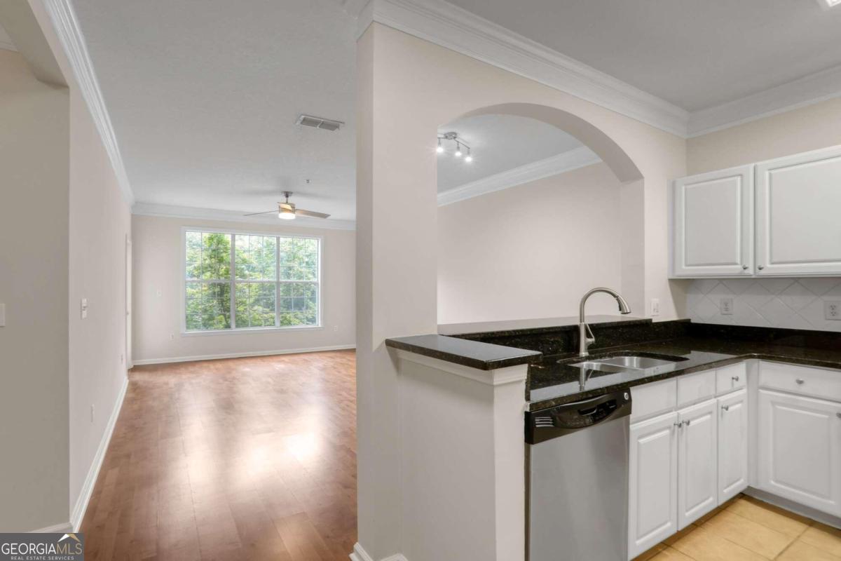 a kitchen with granite countertop a sink and cabinets