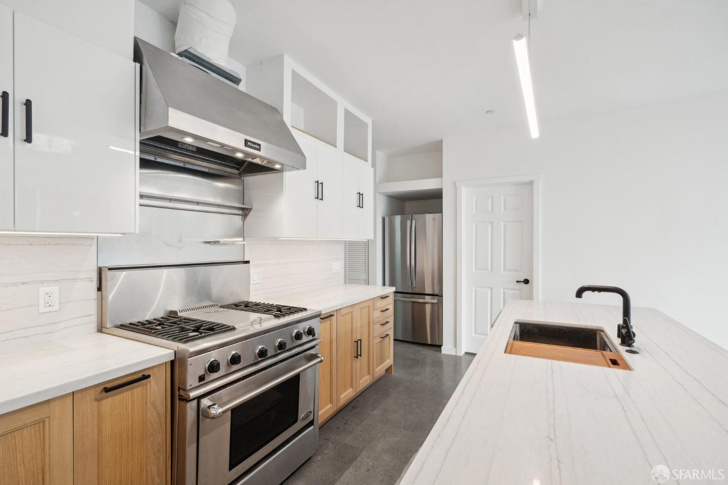 a kitchen with stainless steel appliances a stove a sink and a refrigerator